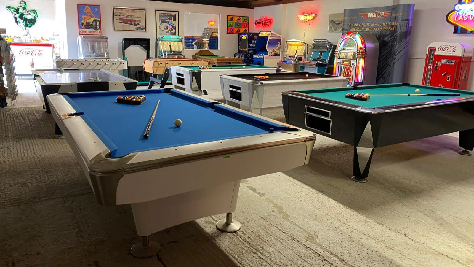 Game room with pool table, arcade machines, and vintage decor.
