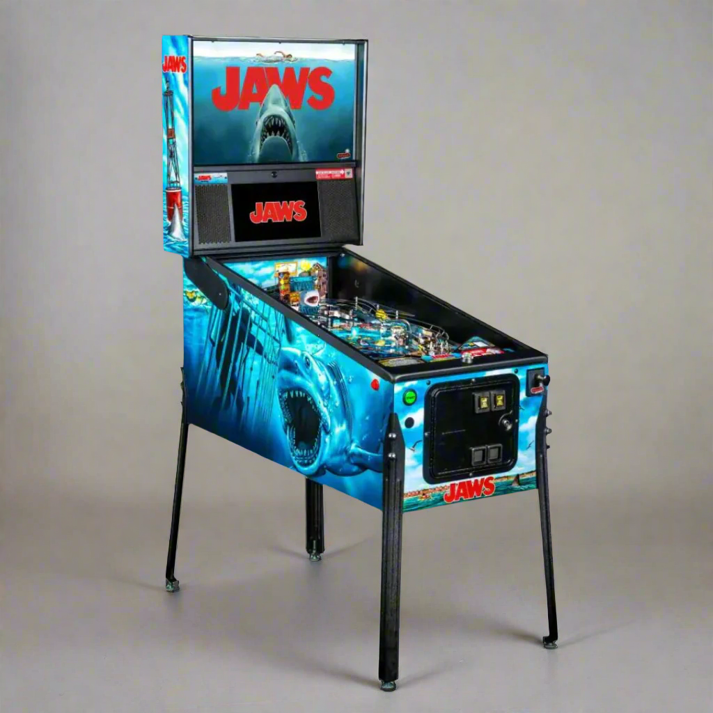 A Jaws pinball machine with a theme based on the Jaws movie, featuring a shark design and movie branding on the body and backglass.