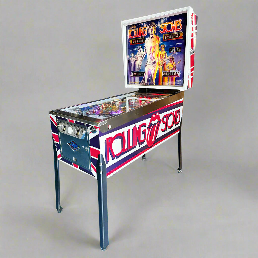 A restored Rolling Stones themed pinball machine with vibrant artwork and a clear protective cover over the playfield.
